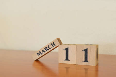 March 11, Date design with calendar cube on wooden table and white background.の写真素材