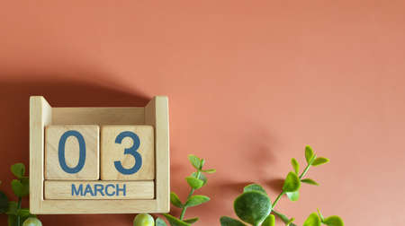 March 3, Date design with calendar cube and leaf on orange background.の写真素材