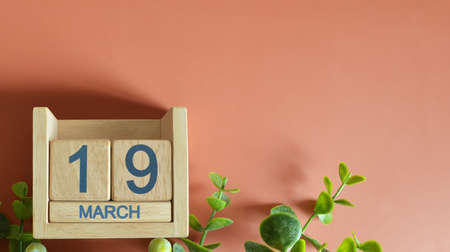 March 19, Date design with calendar cube and leaf on orange background.の写真素材