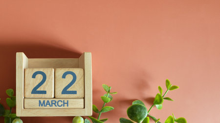 March 22, Date design with calendar cube and leaf on orange background.の写真素材