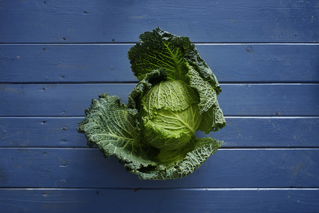 green savoy cabbage on blue vintage tableの写真素材