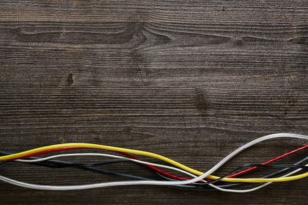colorful cables mixed on dark woodの写真素材