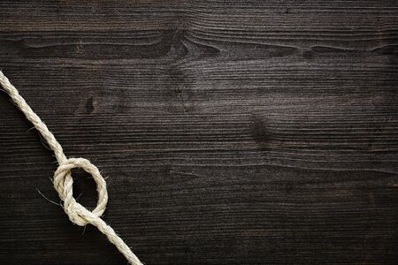 knotted rope on dark woodの写真素材