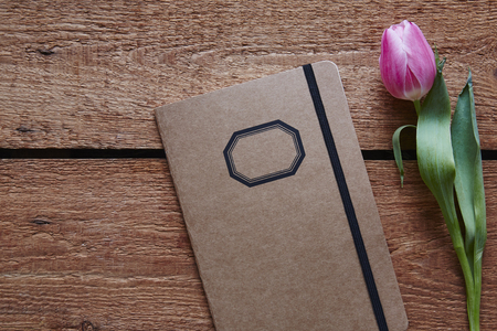 a retro notebook and a tulip spring atmosphere on wooden deskの写真素材