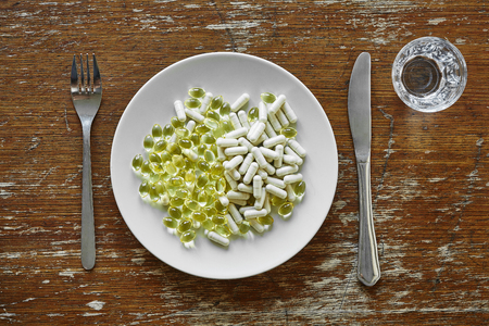 a plate loaded with pills drugs and  nutrition supplementの写真素材
