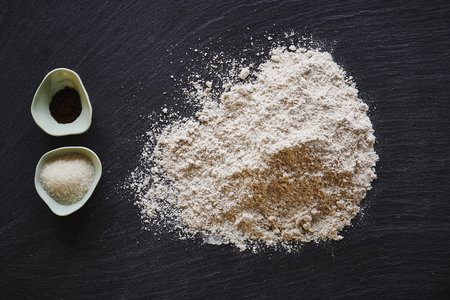 food blog baking ingredients  flour and sugar on dark tableの写真素材