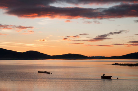 Small boats in peaceful lake before sunrise.の写真素材