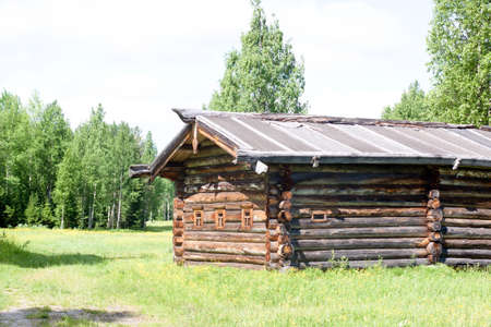 A traditional wooden russian house in a summer forestの写真素材