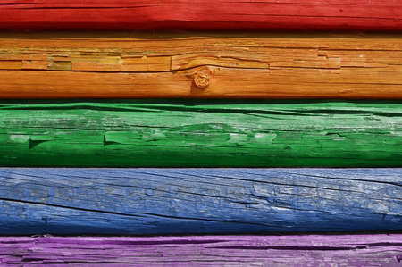 The background of the old wall of logs painted with colored paintの写真素材