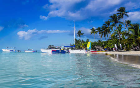 Saona, Dominican Republic - December 26, 2016: Tourist boats off the coast of the Caribbean Sea. The beach of cloudy weather. Rainbow over the islandのeditorial素材