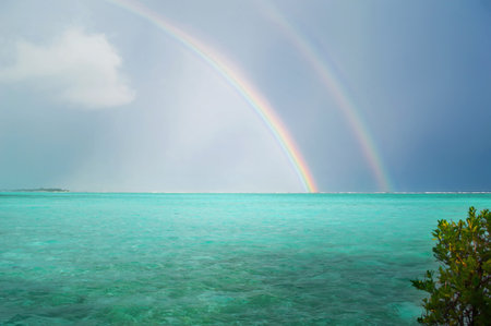 A double rainbow in gloomy weather over an Sun Island in the Indian Ocean. Rainbow after a tropical downpour in the Maldivesの写真素材
