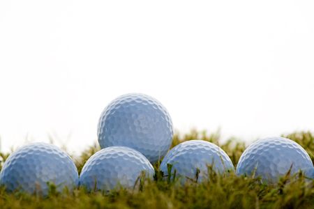 group of golf balls over grass in white backgroundの写真素材