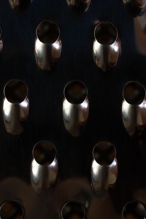 close up on a grater of stainless steel kitchen and detail of its edgesの写真素材
