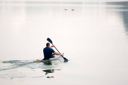 rower with canoe training in a lakeの写真素材