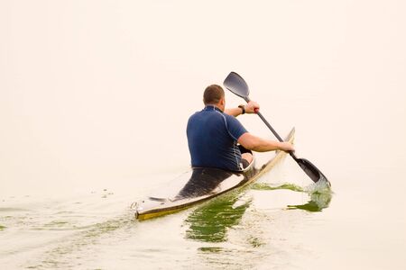 rower with canoe training in a lakeの写真素材