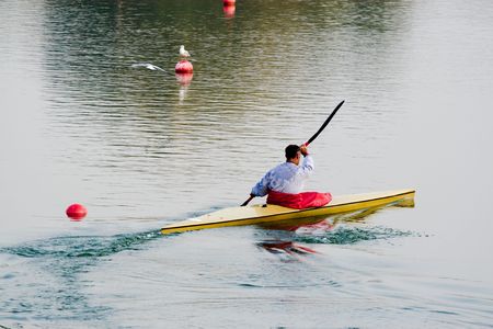 rower with canoe training in a lakeの写真素材
