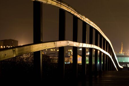 railing of a wooden bridge at night illuminatedの写真素材