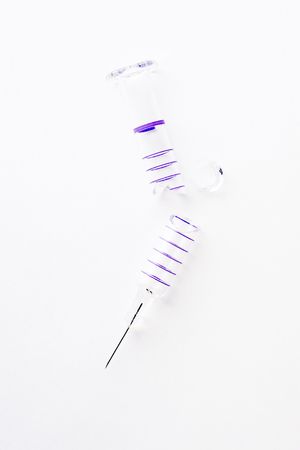 broken hypodermic needle isolated in wait backgroundの写真素材