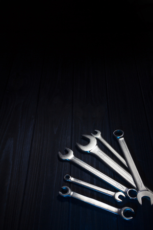 Several of wrenches on dark wooden boardの写真素材
