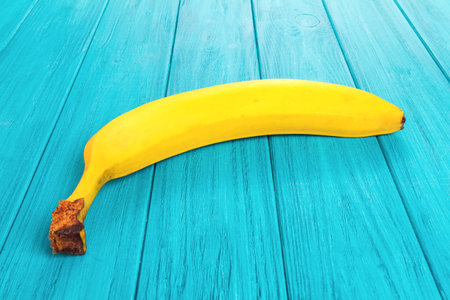 One fresh banana on the blue wooden deskの写真素材