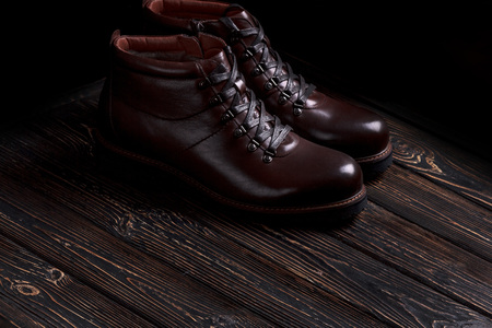 mens boots shoes on a wooden background.の写真素材