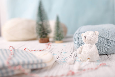 Decorative white bear sits before light blue ball of yarn.の写真素材