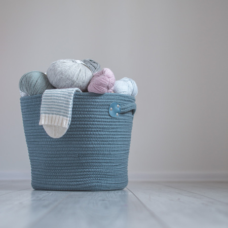 Wool yarn in coils with striped socks in to cotton thread handmade woven basketの写真素材