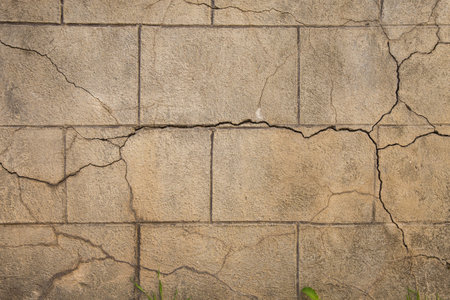 Old distressed big stone block wall with cracks