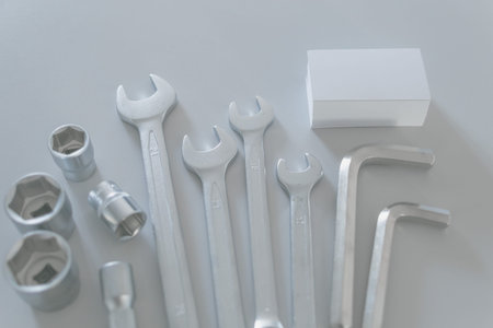 Set of a lot of different tools with blank of business card in pastel colour on light gray...