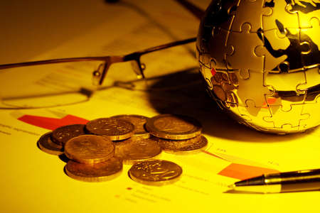 Globe puzzle and Euro coins on business document の写真素材