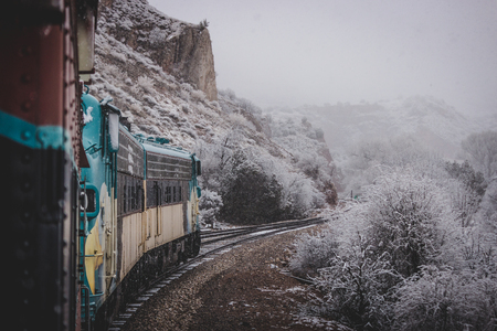 Train passenger perspective of the winding Verde Canyon Railroad with snow covering the trees and rock formations of Verde Canyon, near Perkinsville, Arizonaの写真素材
