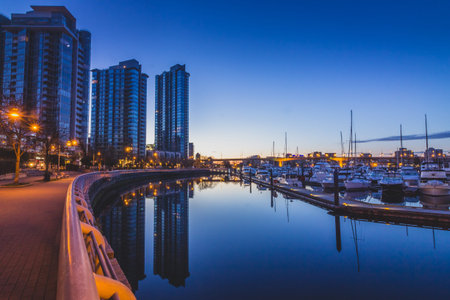 Cityscape from Quayside Marina taken before sunrise with reflections of buildings and boats in the...