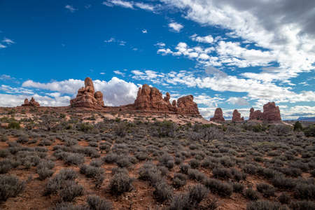 Beautiful cloudscape over Turret Arch and surrounding sandstone rock formations on a sunny day, Arches National Park, Moab, Utahの写真素材