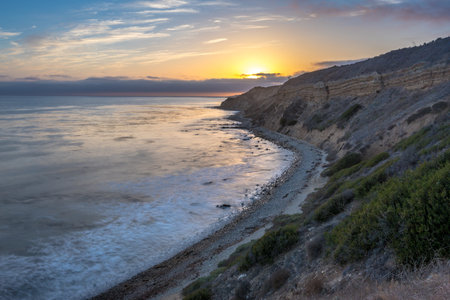 Embark on a serene journey along the Catalina Trail, where the tranquil sunset illuminates the rugged cliffs and coastal splendor of Ocean Trails Reserve, Rancho Palos Verdes, California.の写真素材