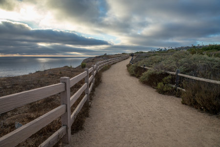 As the sun sets over Golden Cove, its tranquil waters reflect the warm hues of the sky, offering a serene escape amidst the rugged cliffs of Rancho Palos Verdes, California.の写真素材