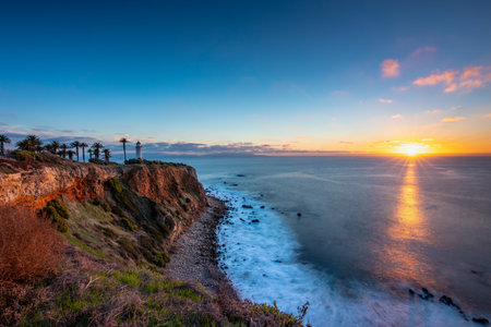 Tranquil sunset paints the sky above Point Vicente, casting golden hues over the rugged coastline, a serene moment in Rancho Palos Verdes, California.の写真素材