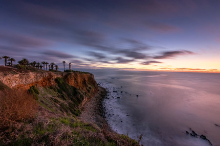 Tranquil sunset paints the sky above Point Vicente, casting golden hues over the rugged coastline, a serene moment in Rancho Palos Verdes, California.の写真素材