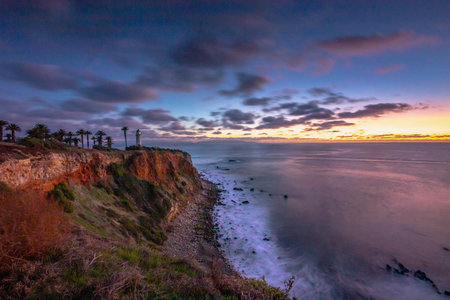 Tranquil sunset paints the sky above Point Vicente, casting golden hues over the rugged coastline, a serene moment in Rancho Palos Verdes, California.の写真素材