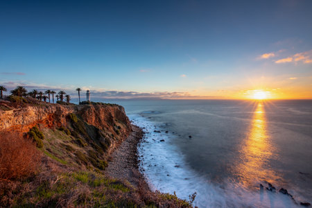 Tranquil sunset paints the sky above Point Vicente, casting golden hues over the rugged coastline, a serene moment in Rancho Palos Verdes, California.の写真素材