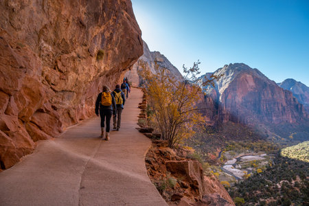 Adventurous individuals trek along the scenic trails of The West Rim Trail in Zion National Park, revealing breathtaking views of sandstone cliffs and the vibrant landscape below.の写真素材