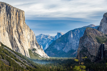 Hikers explore the iconic Yosemite Valley, surrounded by rugged cliffs and breathtaking mountain scenery in Sierra Nevada.の写真素材