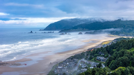 Aerial shot over Cannon Beach, Oregon on a foggy morning, featuring moody coastal sceneryの写真素材