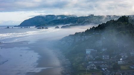 Aerial shot over Cannon Beach, Oregon on a foggy morning, featuring moody coastal sceneryの写真素材