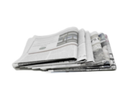 Newspaper folded and stacked black and white background blurred