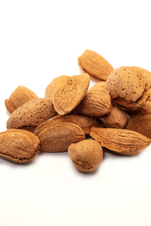 Almonds in their skins isolated on white background.の写真素材