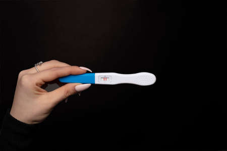 Female hand showing positive pregnancy test.の写真素材