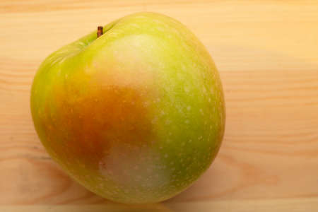 Signle green apple on a wooden backgroundの写真素材