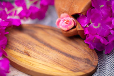 Brown wooden plate with pink flowersの写真素材