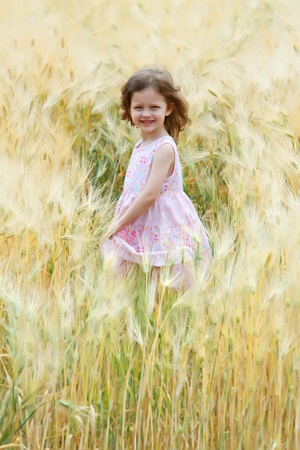 a little girl sing and dance in a field of ryeの写真素材