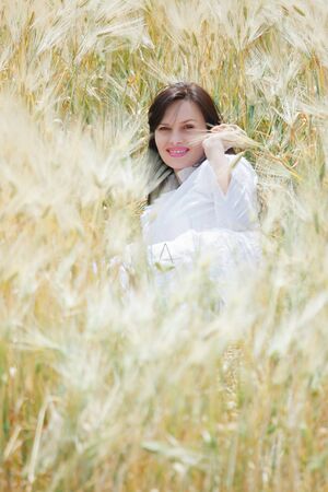 Young sexy woman lying in a field of rye, happy, smiling and having fun の写真素材